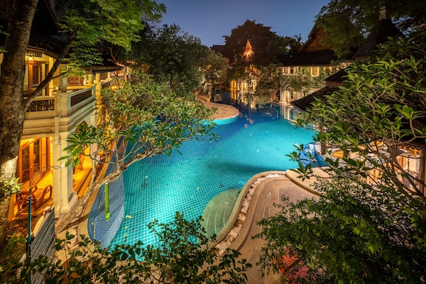 Alberca al aire libre, sombrillas en la alberca y camastros