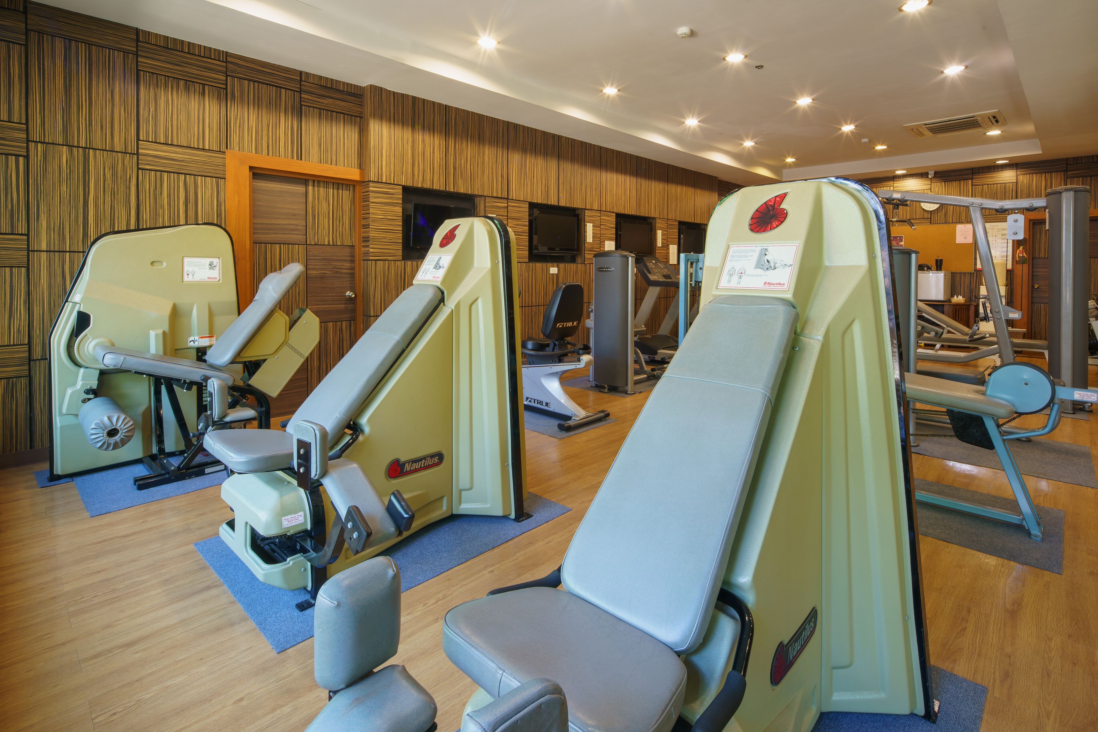 A fitness center with various exercise machines and seating areas.