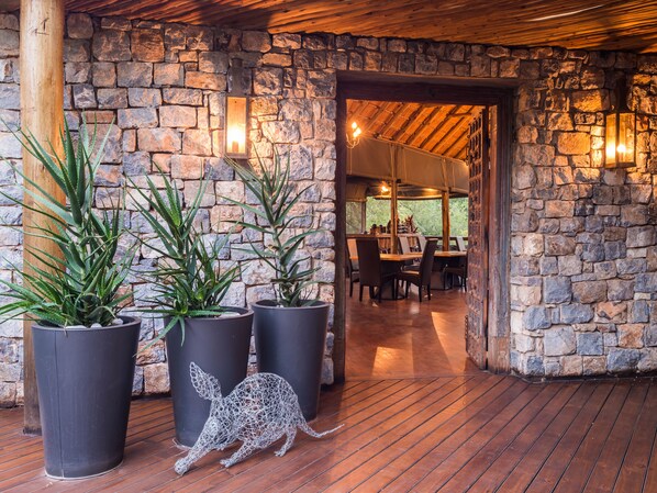 Interior de paredes de piedra con plantas en macetas y una escultura de canguro.
