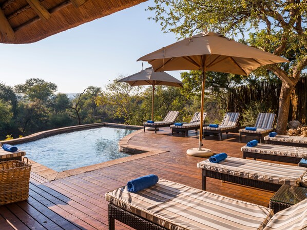 Utomhuspool, parasoller och solstolar