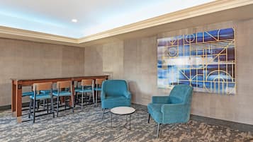A conference room with a long table, four chairs, and two round tables.