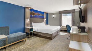 A hotel room with a bed, a desk, a chair, a sofa, a painting, and a window. - Best Western Plus Glen Allen Inn (Glen Allen)