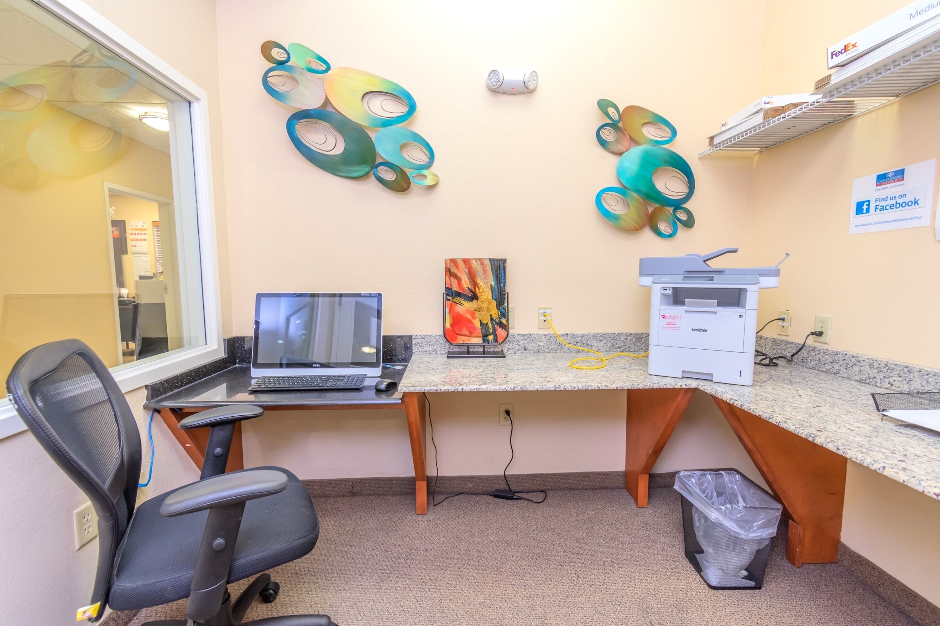 Un bureau équipé d’un bureau, d’un ordinateur, d’une imprimante et d’une poubelle.