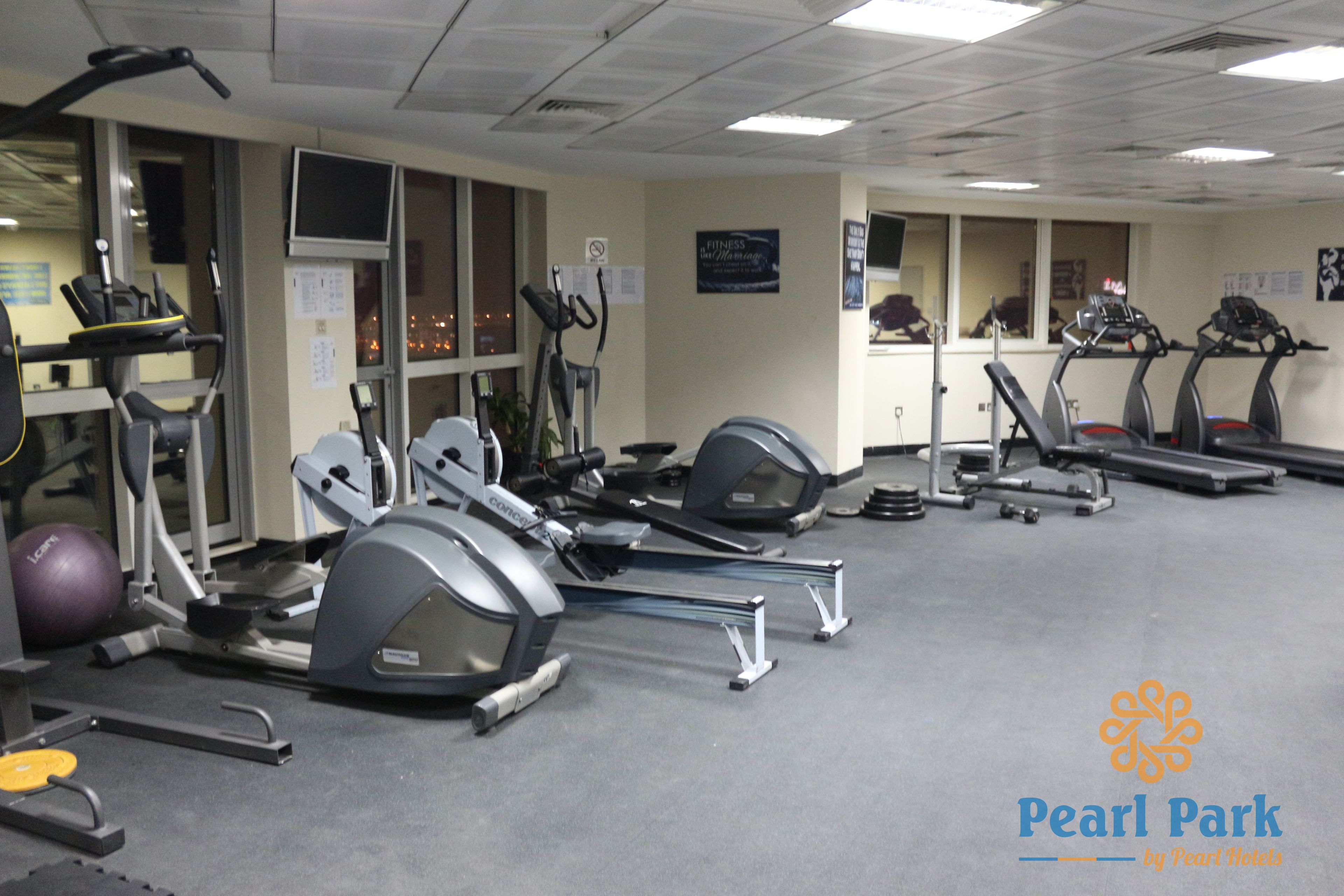 A gym with treadmills, elliptical machines, and a stationary bike.