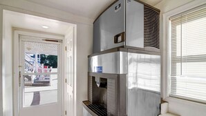 Cocina de acero inoxidable con dispensador de agua integrado y ventana con persianas.