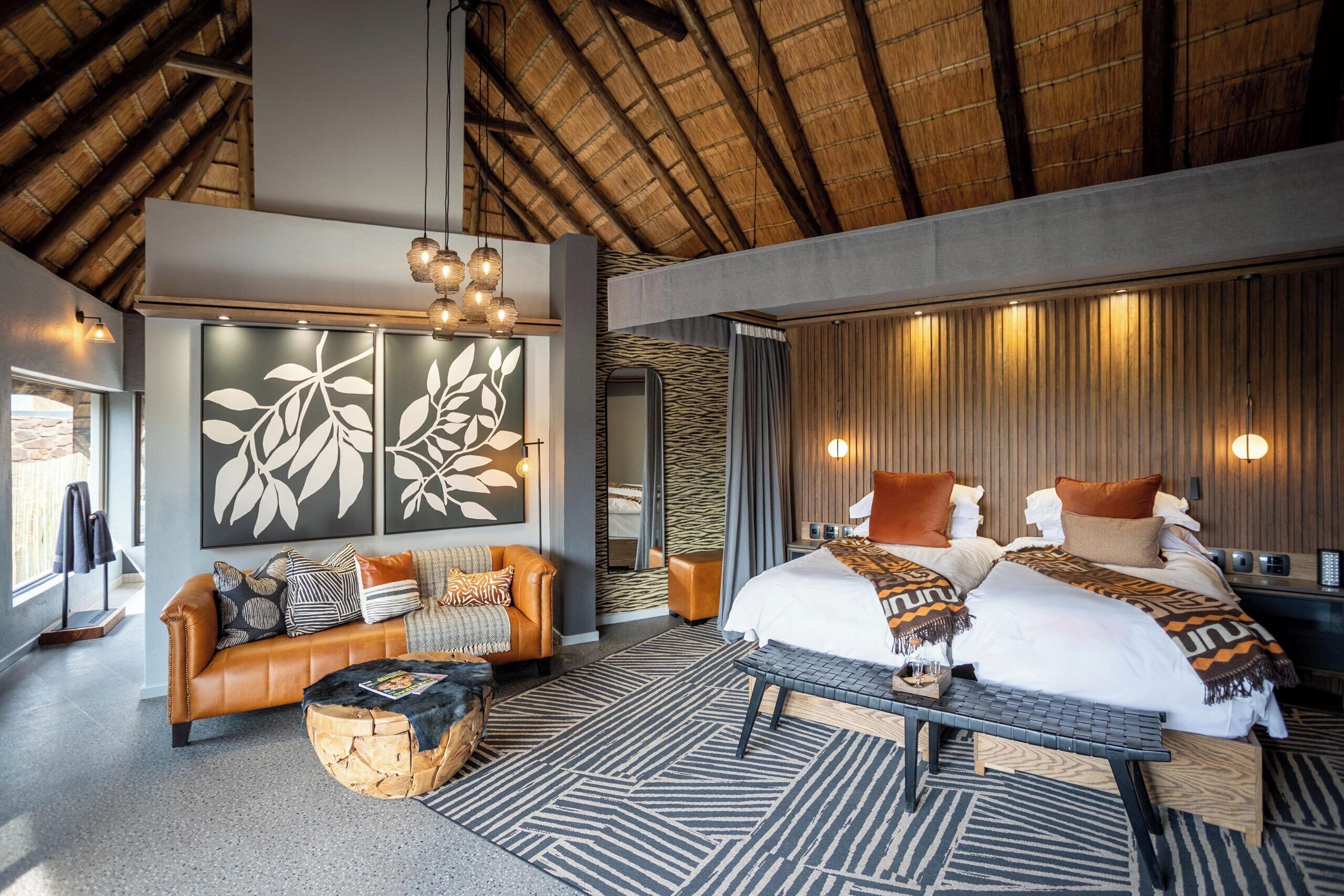 A modern bedroom with a large bed, a sofa, and a dining table.