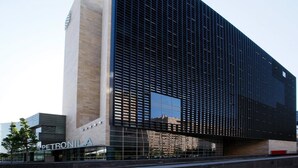 Un edificio moderno con una amplia fachada de vidrio y un llamativo letrero que dice 'PETRONILA'.