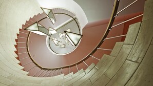Una escalera en espiral con diseño circular y una lámpara en el centro.