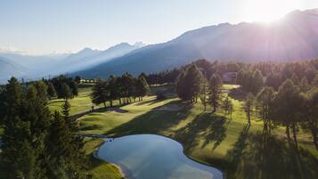 Stunning golf course with manicured fairways, lush grass, and a serene pond.