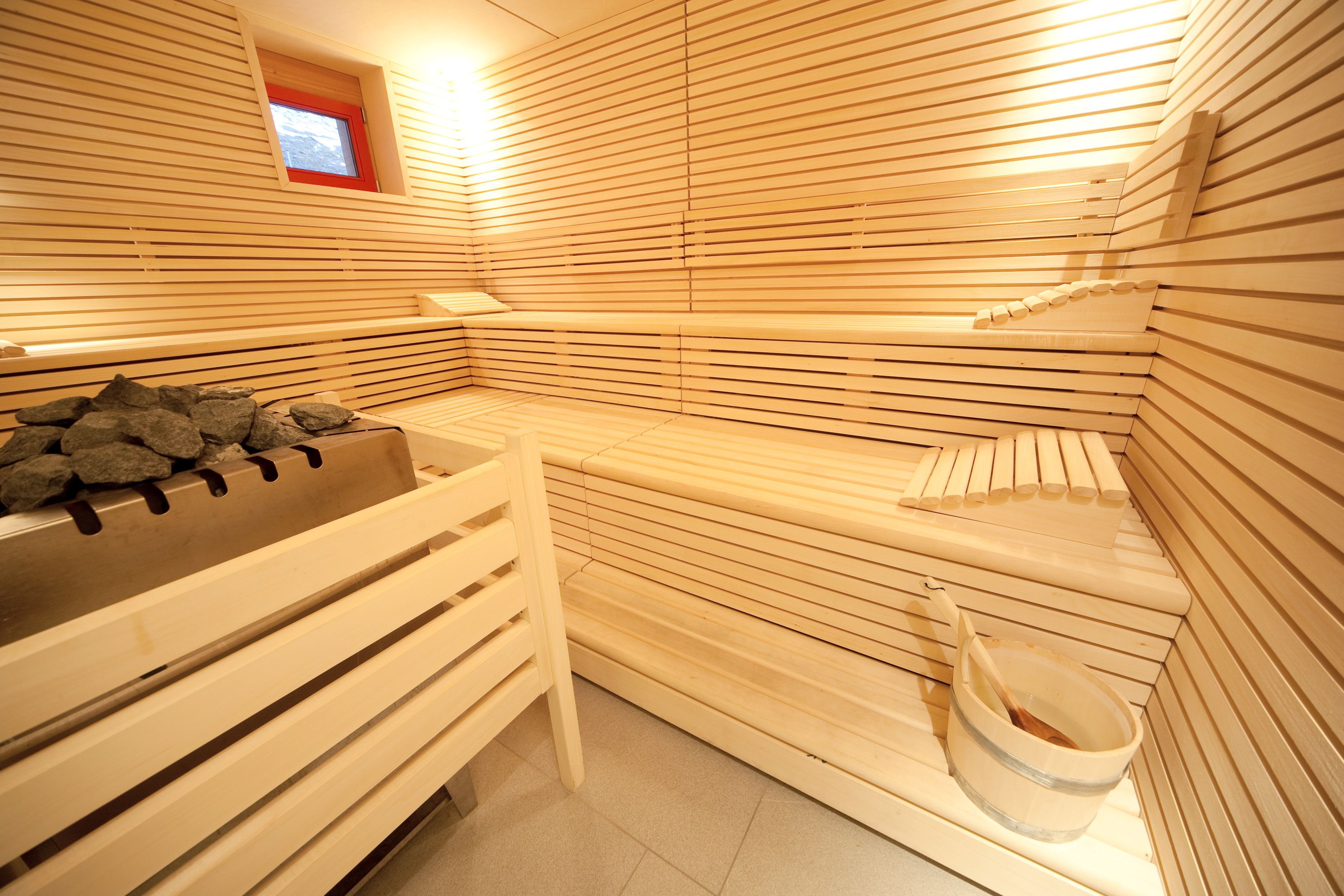 A sauna with wooden benches and a stone bench.