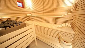 A sauna with wooden benches and a stone bench.