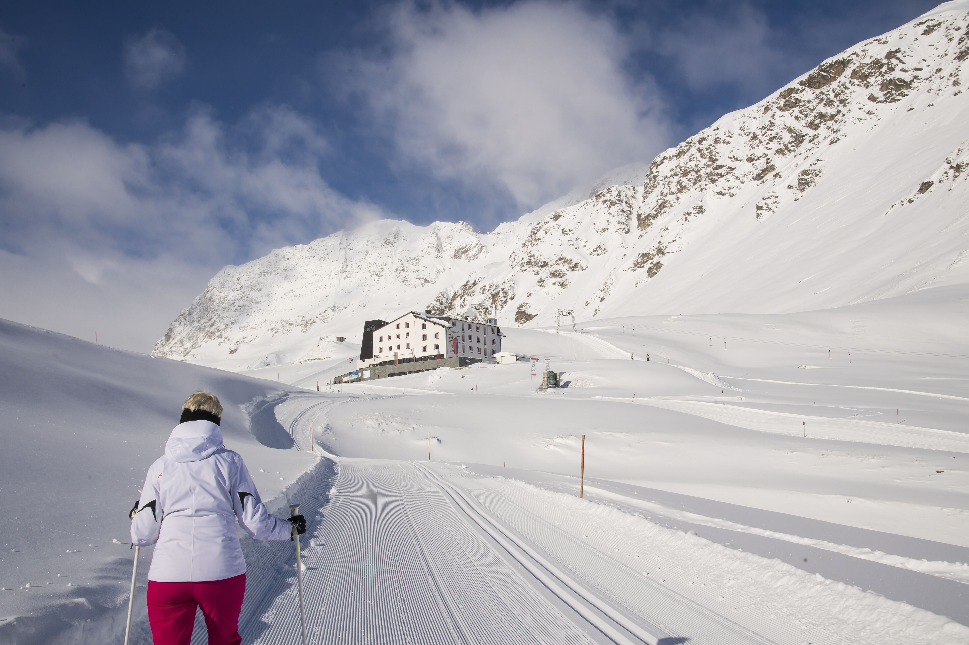 Une piste de ski enneigée, avec un bâtiment visible au loin.