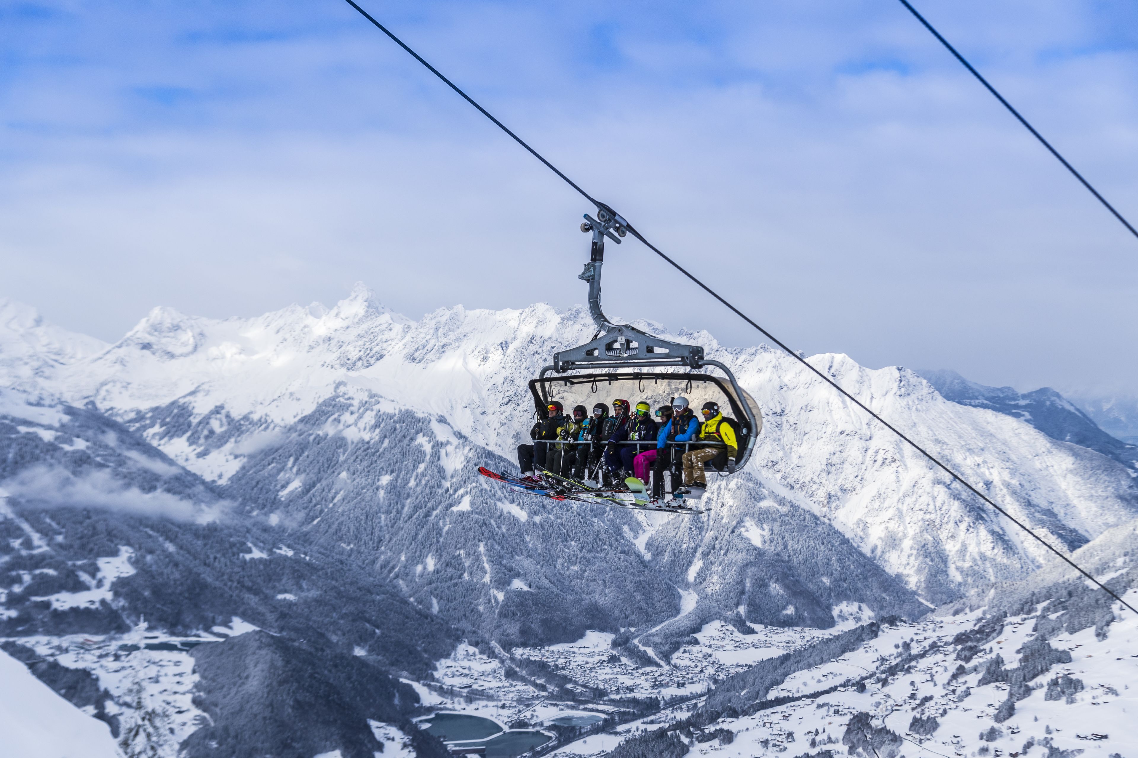 Un teleférico con pasajeros subiendo una montaña nevada.