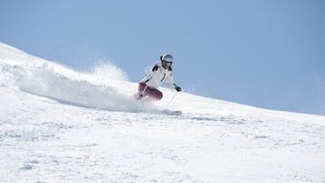 Iemand skiët een besneeuwde helling af.