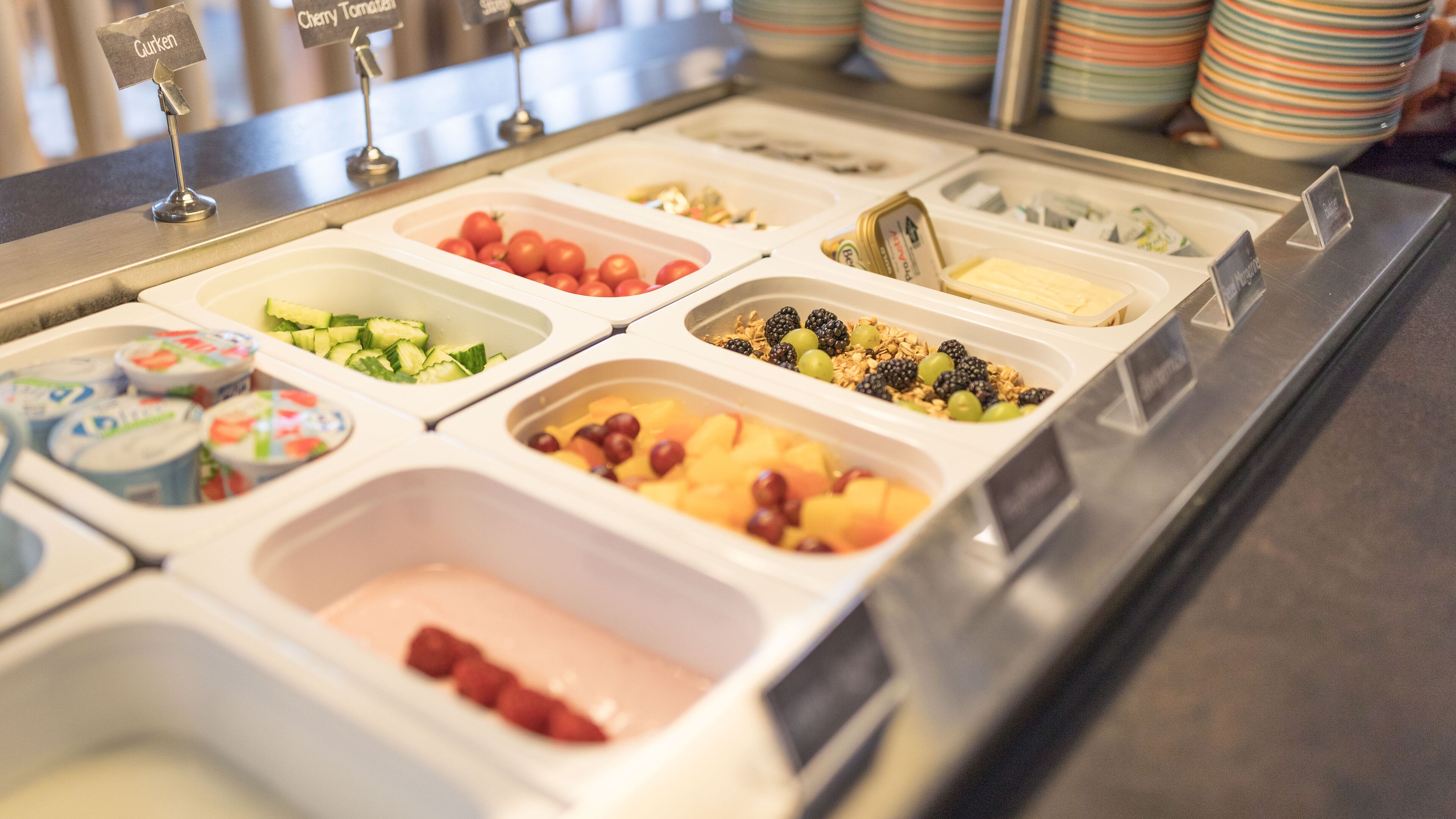 A food display with various fruits and yogurt containers.