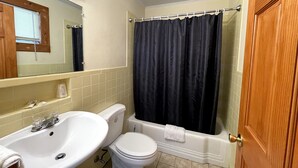 A bathroom with a sink, toilet, and bathtub. - The Riverside Inn (Stowe)