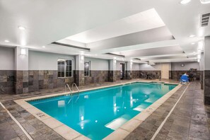 An indoor swimming pool with clear water, surrounded by stone walls and a tiled floor. - La Quinta Inn & Suites by Wyndham Conway (Conway)