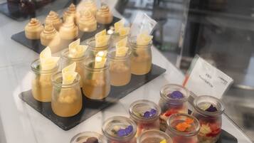 A display of desserts in glass jars with various toppings and decorations.
