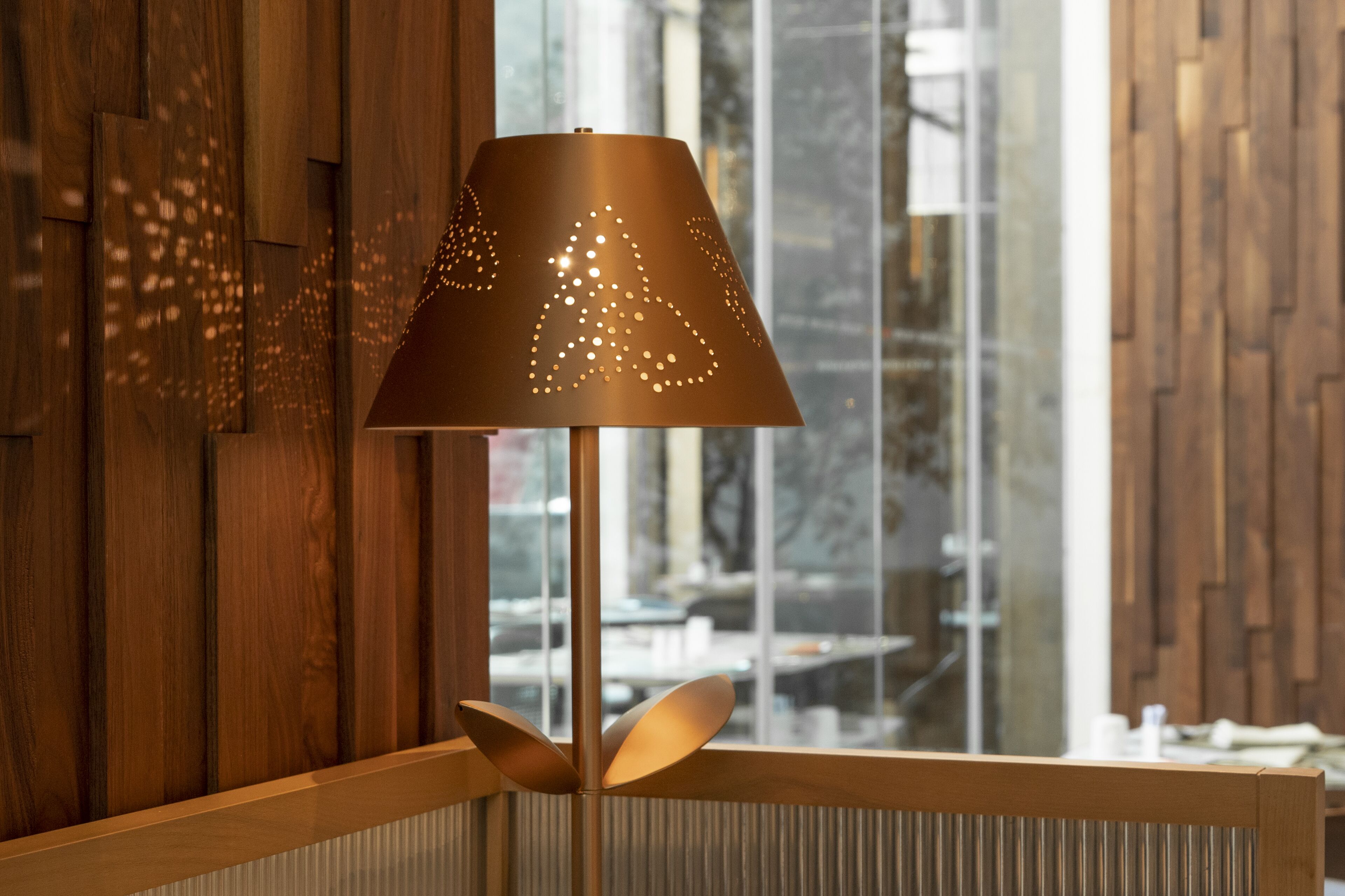 A lamp with a geometric design on a wooden floor.