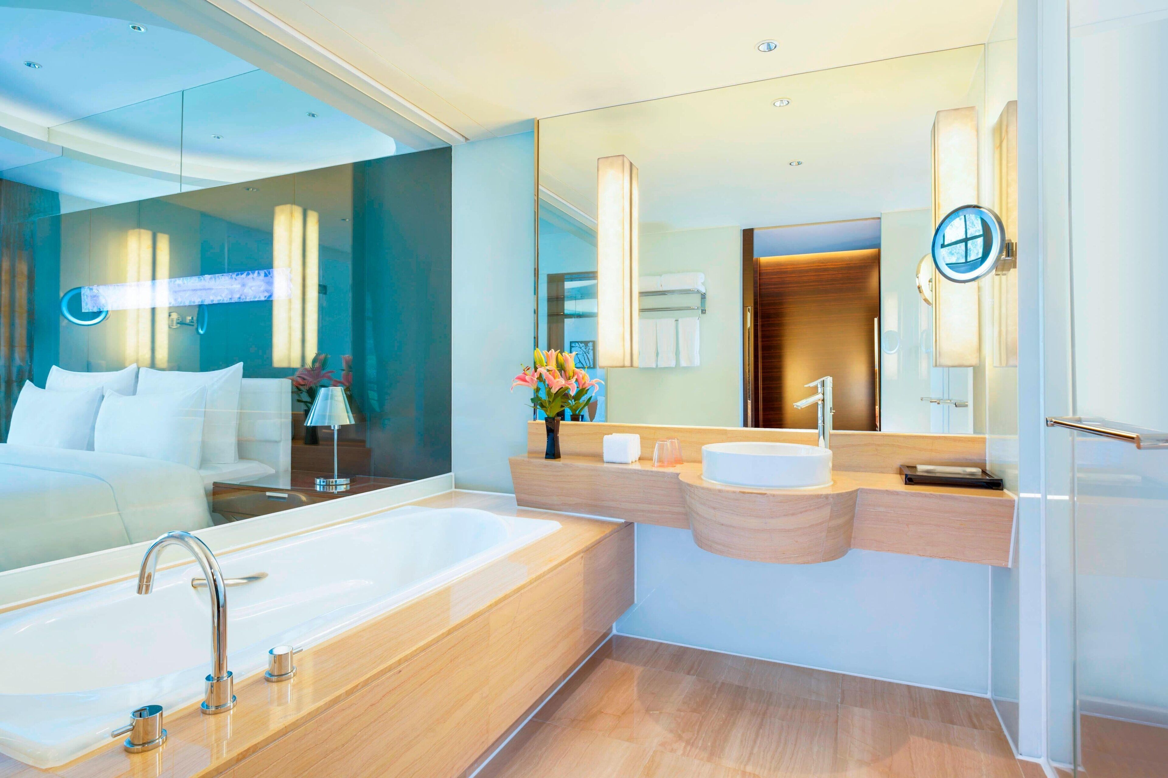 A modern bathroom with a large bathtub, a vanity with a mirror, and a shower area.
