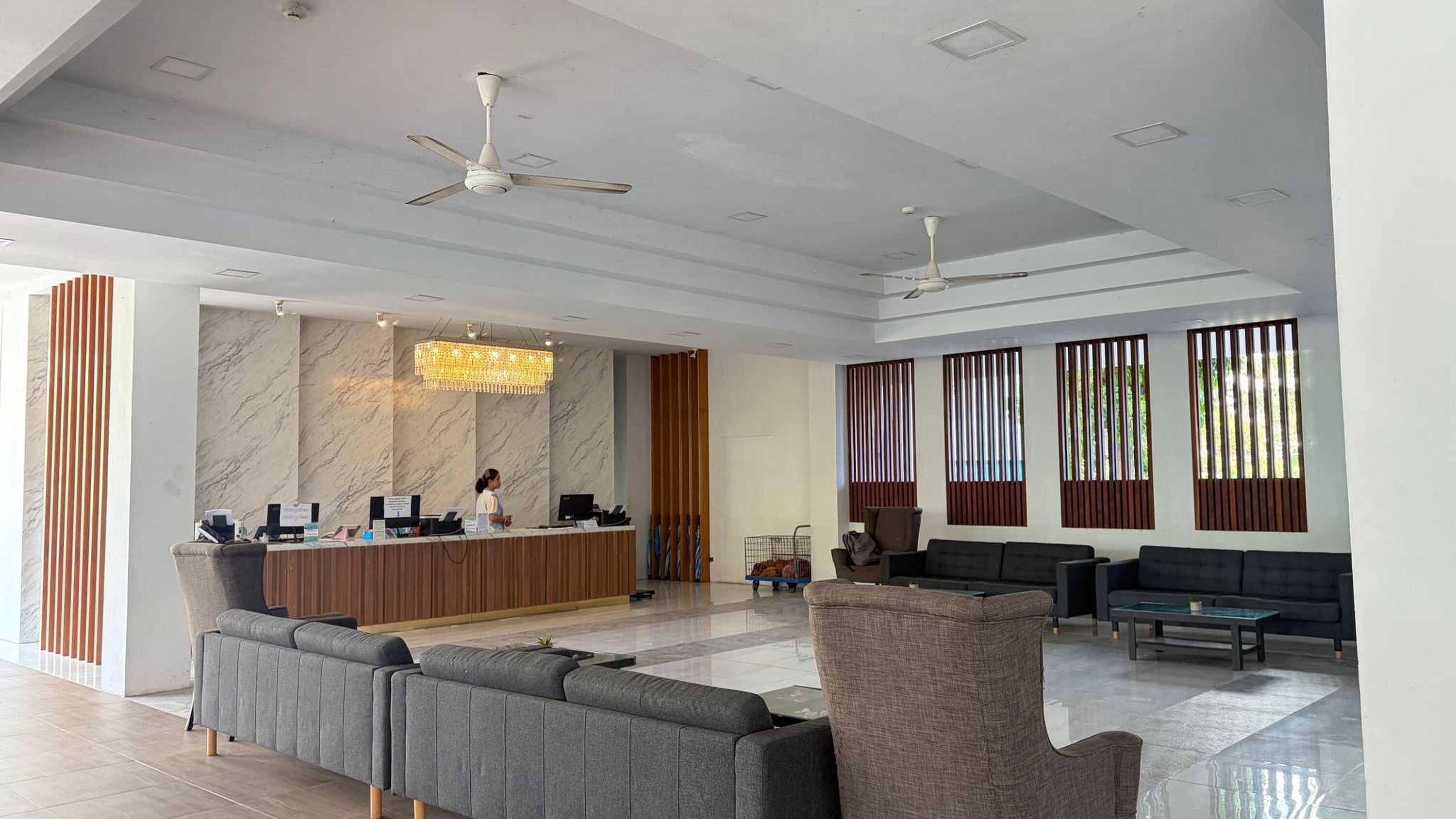 Eine geräumige Lobby mit Empfangstresen, Sitzgelegenheiten und großen Fenstern.