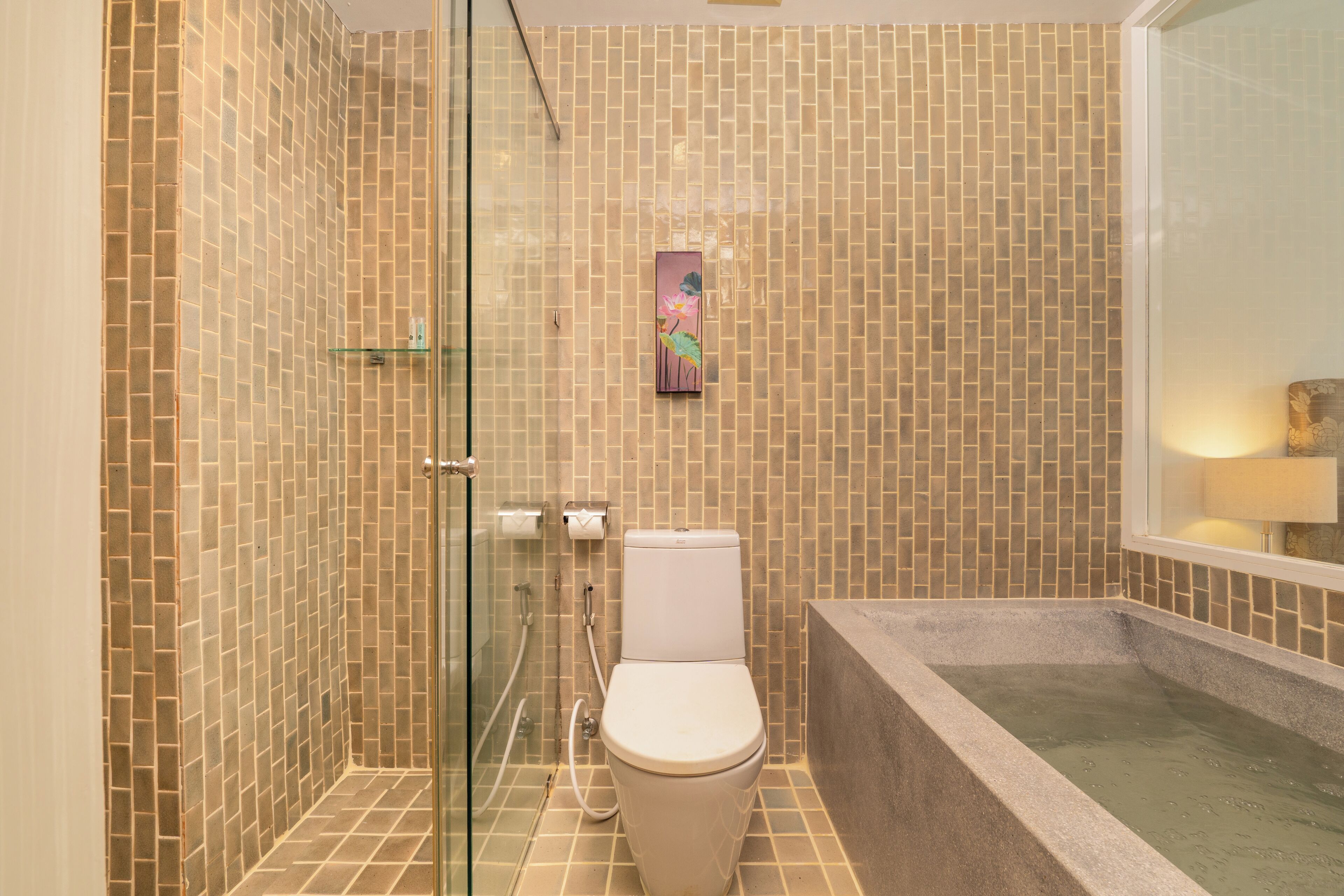 A bathroom with a glass shower enclosure, a toilet, and a bathtub.