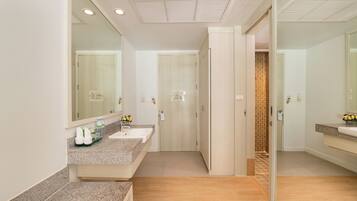 Un baño moderno con un espejo grande, un lavabo y una zona de ducha.