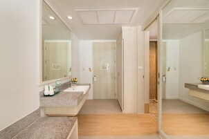 Un baño moderno con un espejo grande, un lavabo y una zona de ducha.