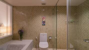 A bathroom with a toilet, a glass shower enclosure, and a bathtub.