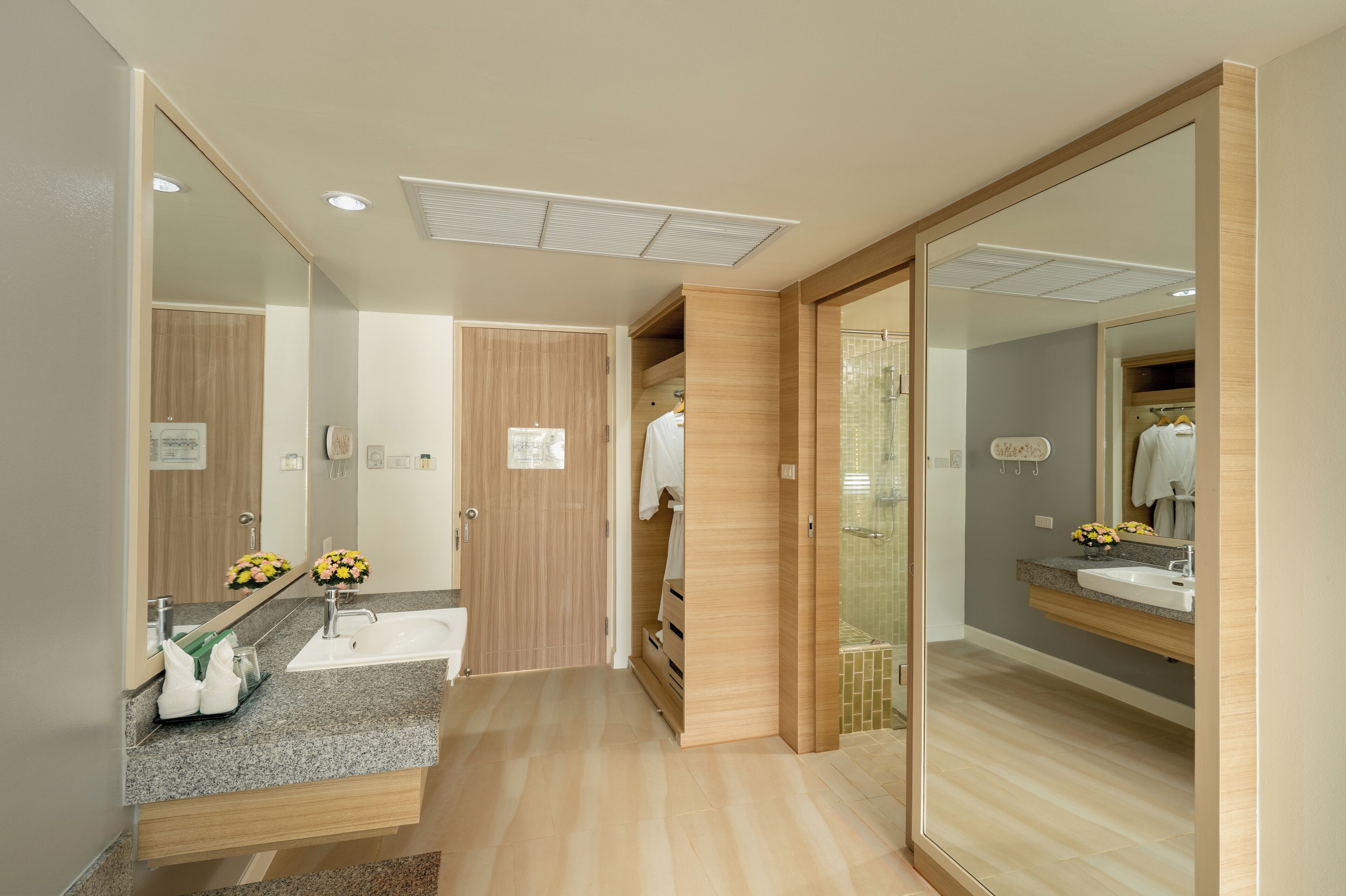 Un baño moderno con tocador, lavabo y espejo.