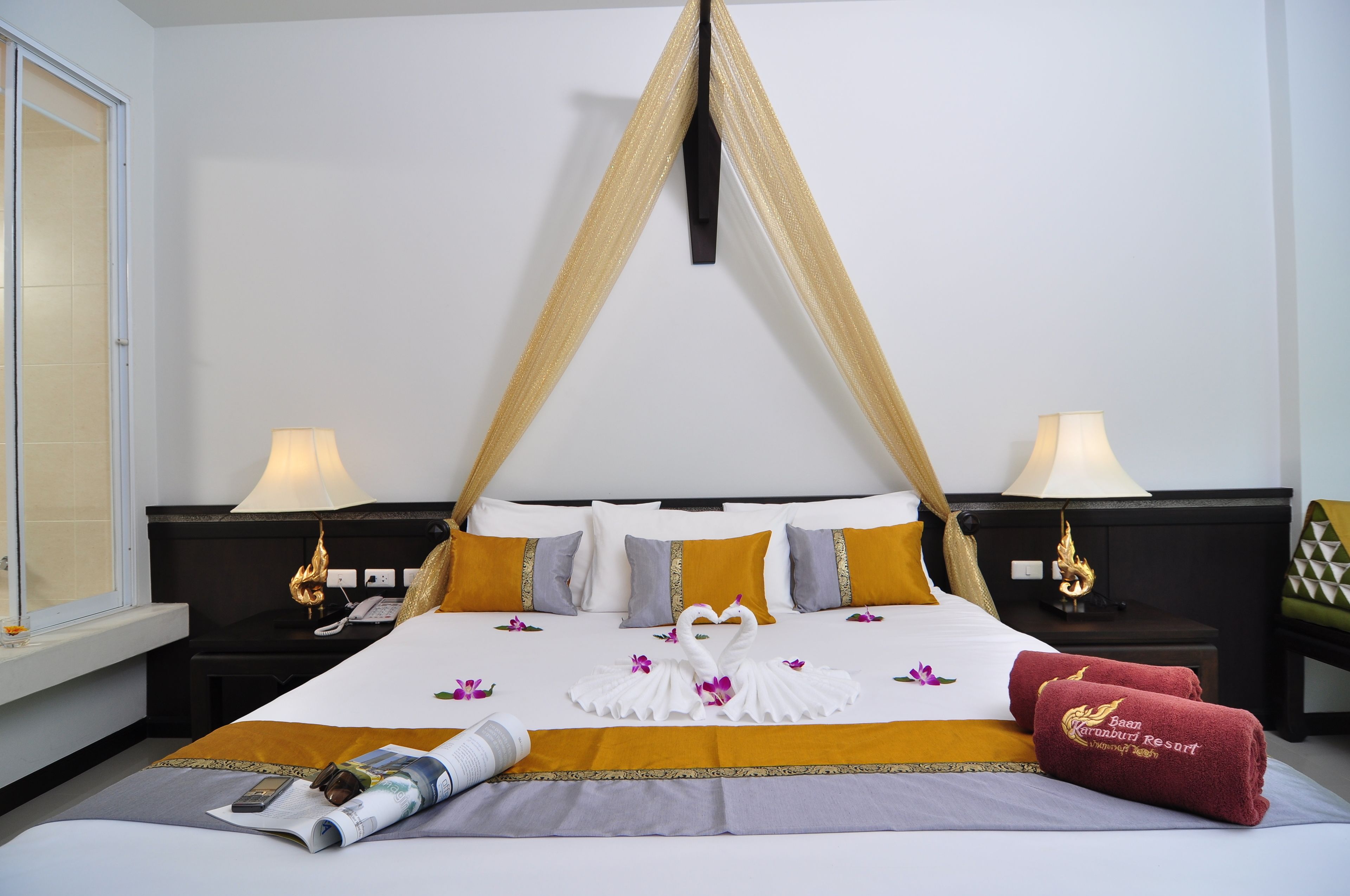 A hotel room with a bed, two nightstands, a window, and a curtain.