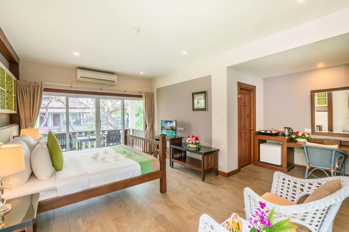 Habitación de hotel con cama, escritorio, silla y vistas al exterior.