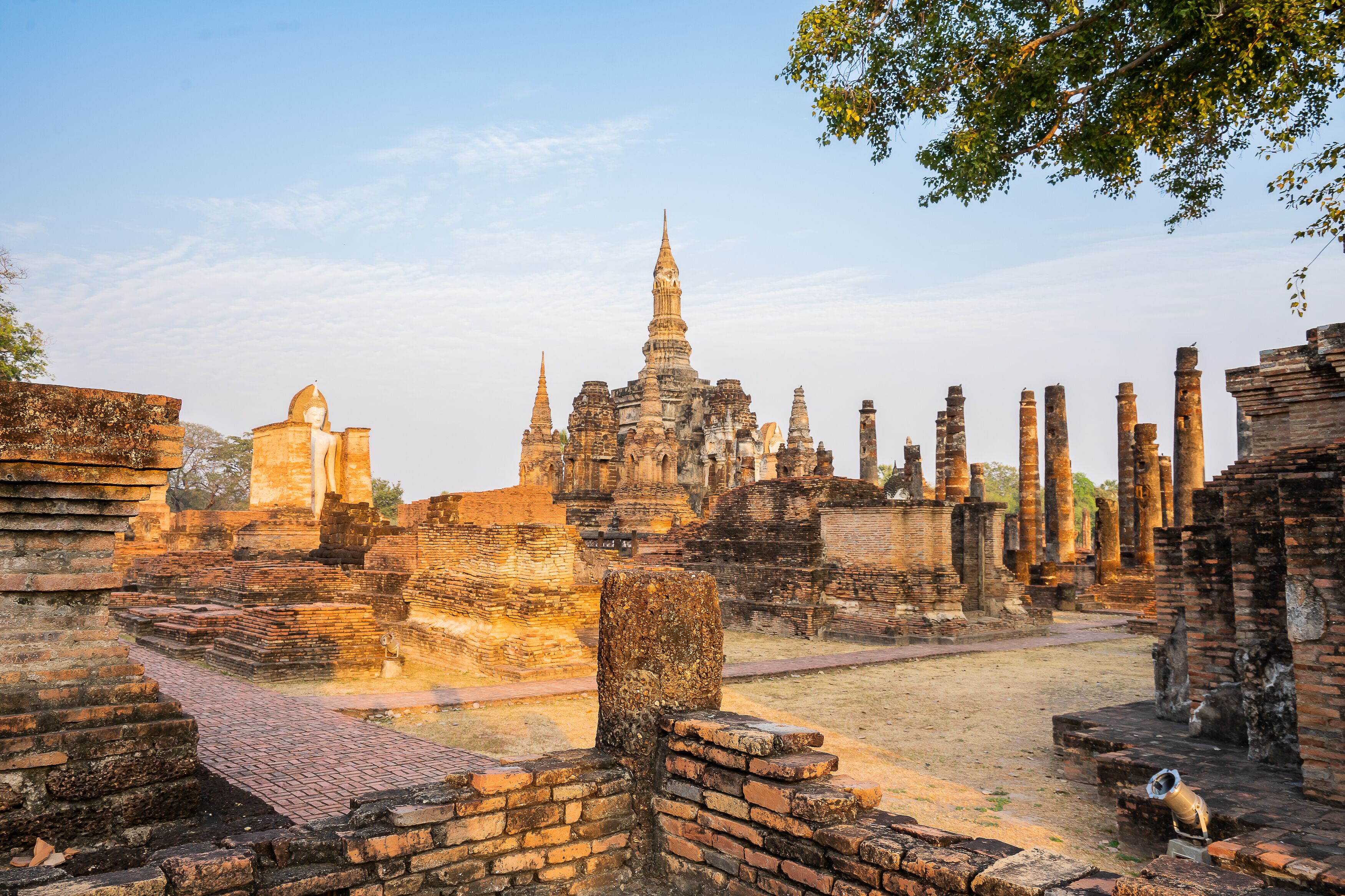 Ancient ruins with a prominent central structure and multiple smaller buildings.