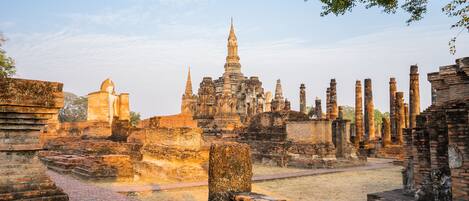 Ancient ruins with a prominent central structure and multiple smaller buildings.