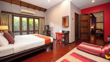 A hotel room with a bed, a desk, a chair, and a sofa.