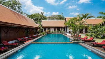 Una piscina al aire libre, sombrillas