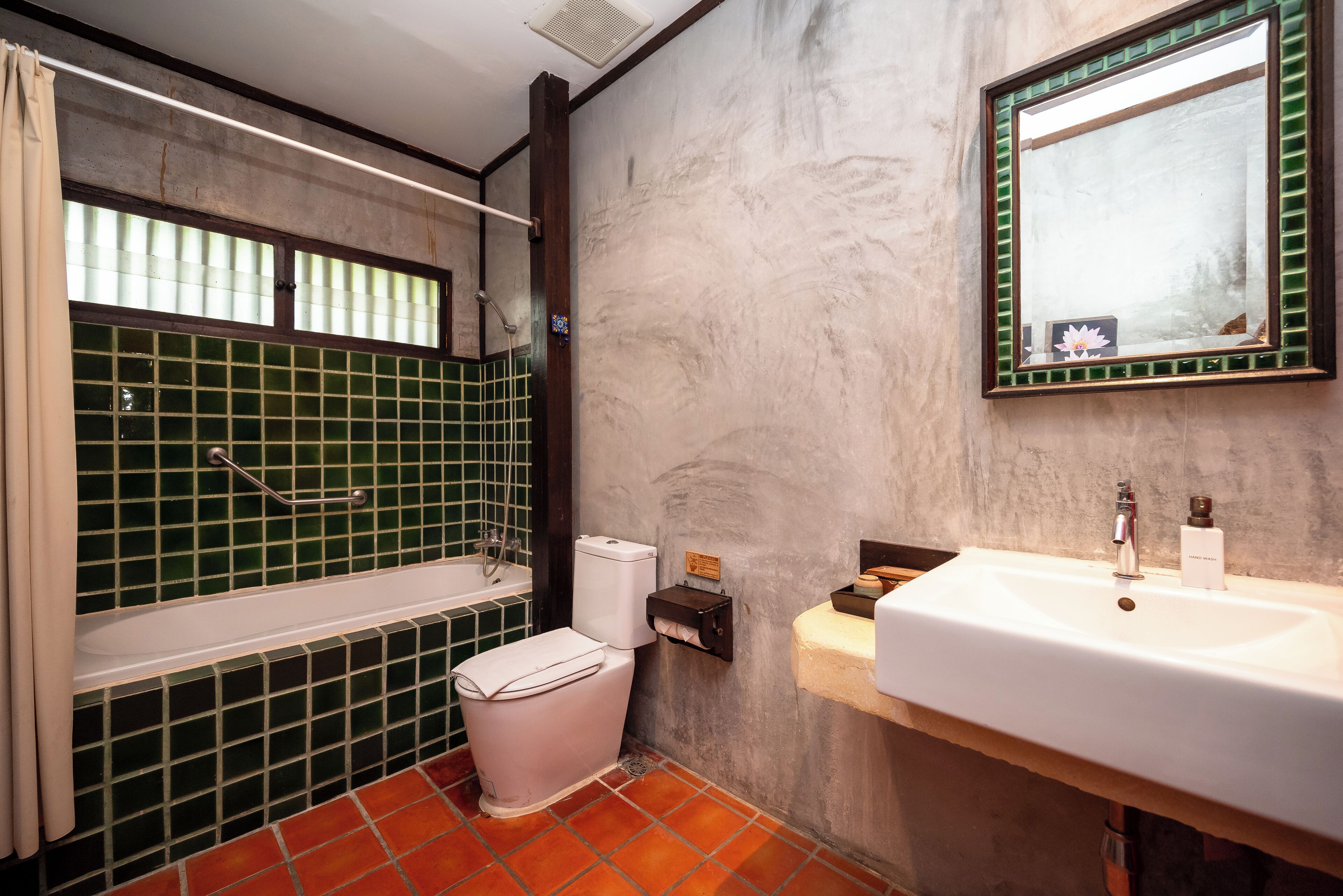 A bathroom with a bathtub, toilet, and sink.