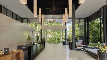 Relax in the open-plan lobby, featuring a central seating area, reception desk, and floor-to-ceiling windows.