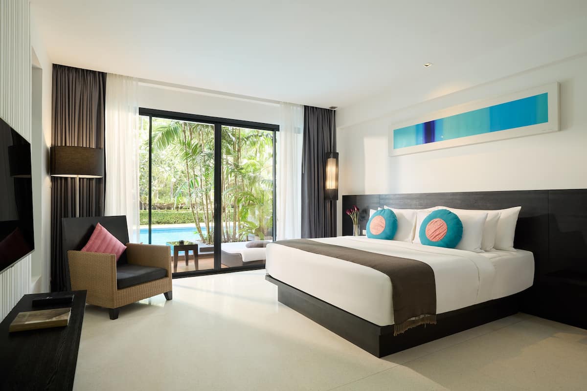 Habitación de hotel moderna con una cama grande, un sofá, un televisor y vista a una piscina.