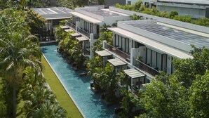 Un complejo turístico con varias edificaciones, una piscina y abundante vegetación.