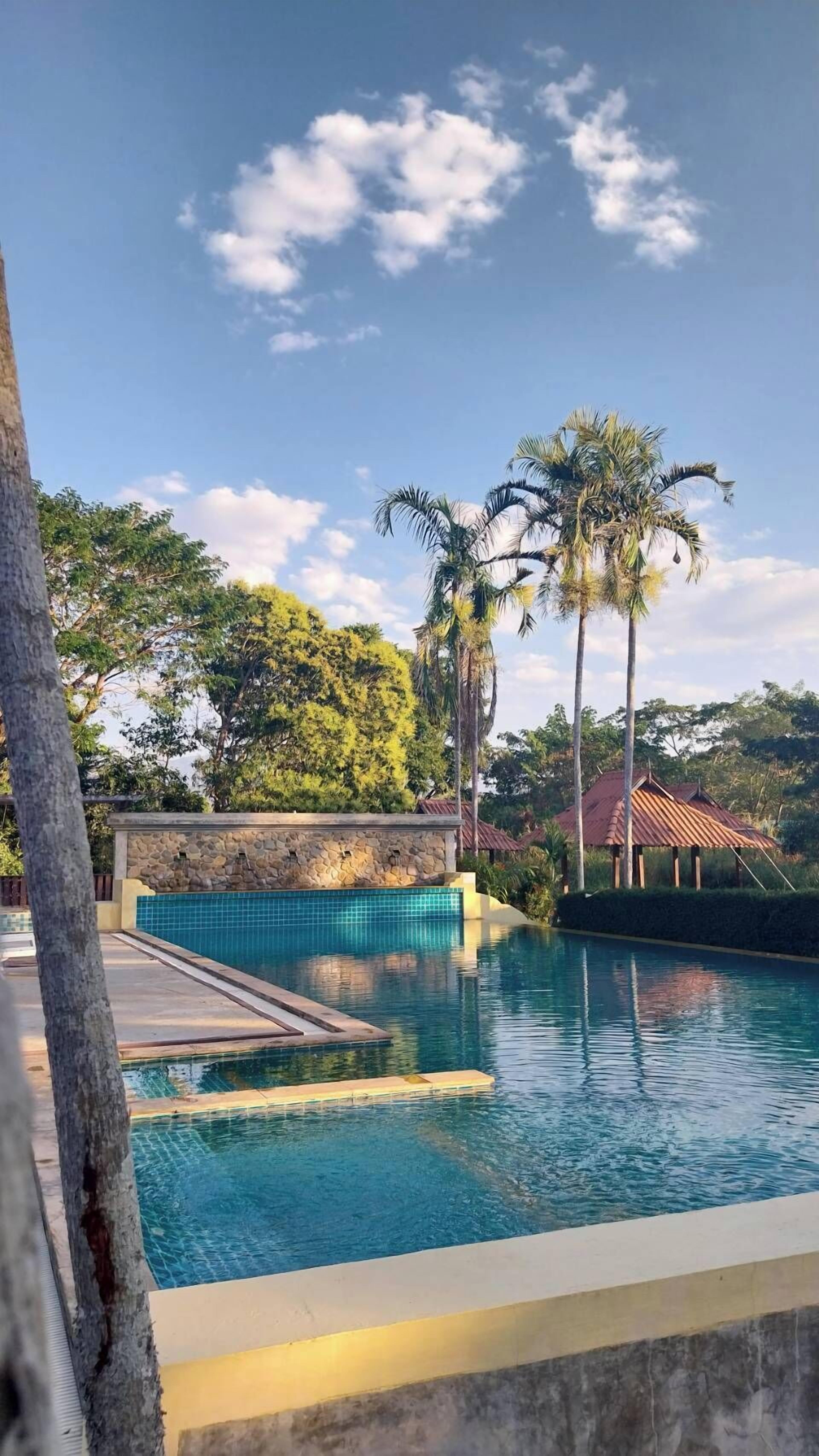 Una piscina al aire libre, camas de piscina gratis, sombrillas