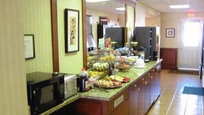 A buffet area with a microwave, toaster, and various food items on a counter. - Whitman Motor Lodge (Huntington Station)