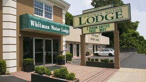 Whitman Motor Lodge with a sign indicating 2-room suites and free WiFi. - Whitman Motor Lodge (Huntington Station)