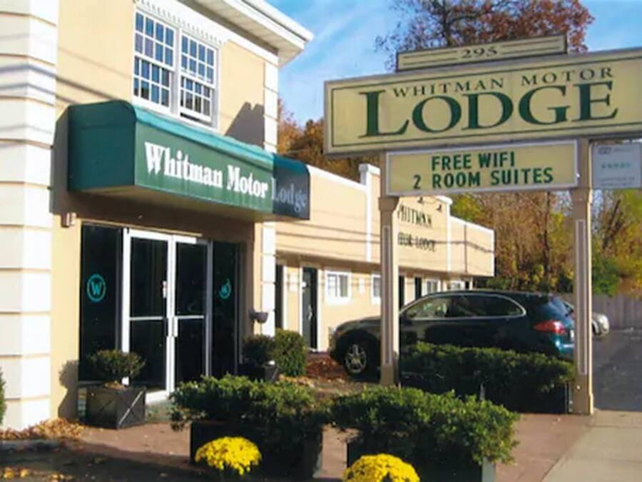 Un motel llamado Whitman Motor Lodge con un letrero que indica WiFi gratuito y suites de dos habitaciones.
