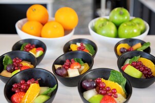 Una mesa con cuencos de fruta dispuestos en fila.