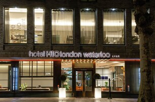 Esterno dell'Hotel H10 London Waterloo, con vista chiara sull'ingresso, l'area salotto e piante in vaso.