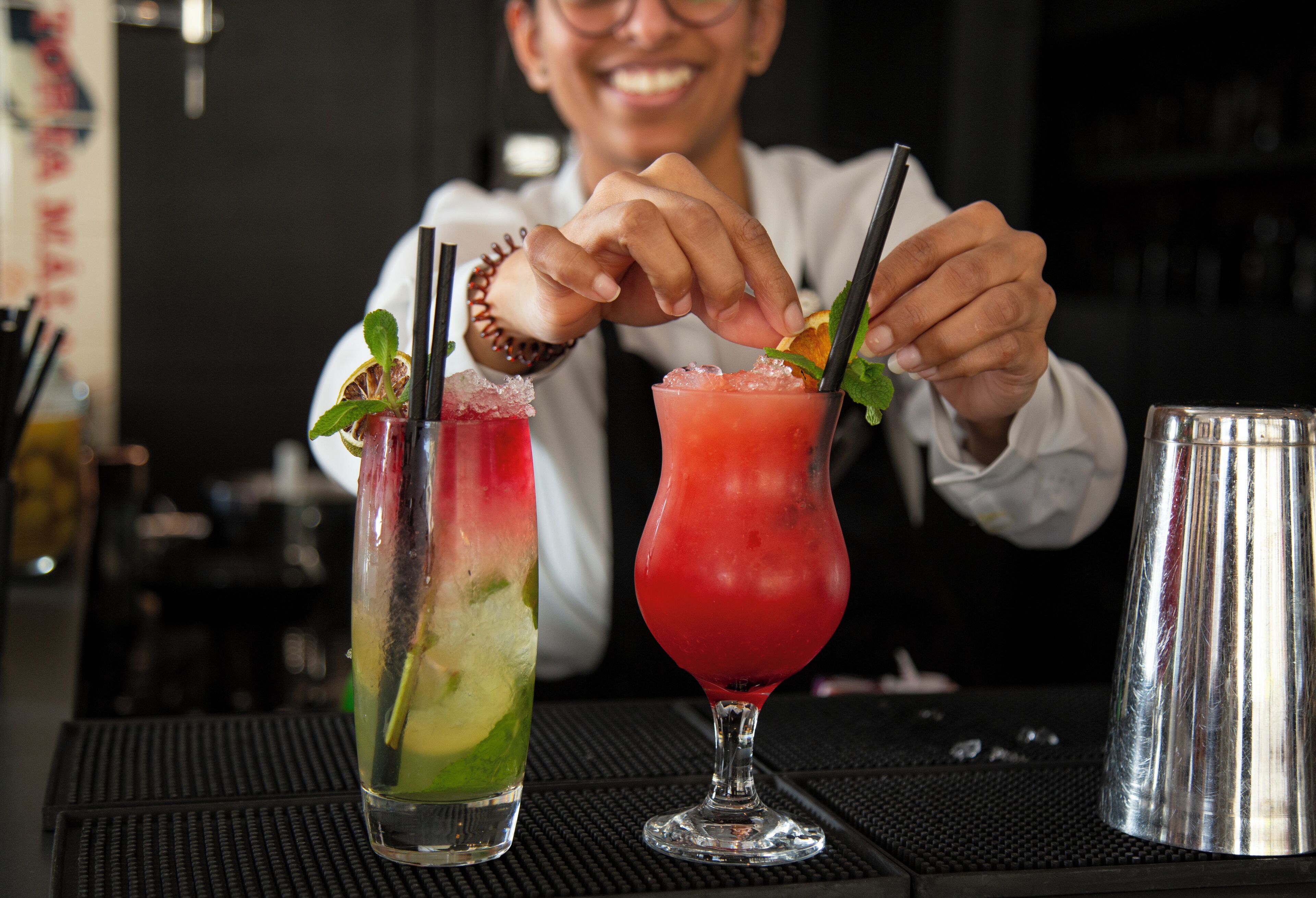 Um bartender prepara bebidas num bar.