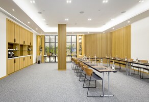 Ein Konferenzraum mit einem langen Tisch, Stühlen und einer zentralen Säule.