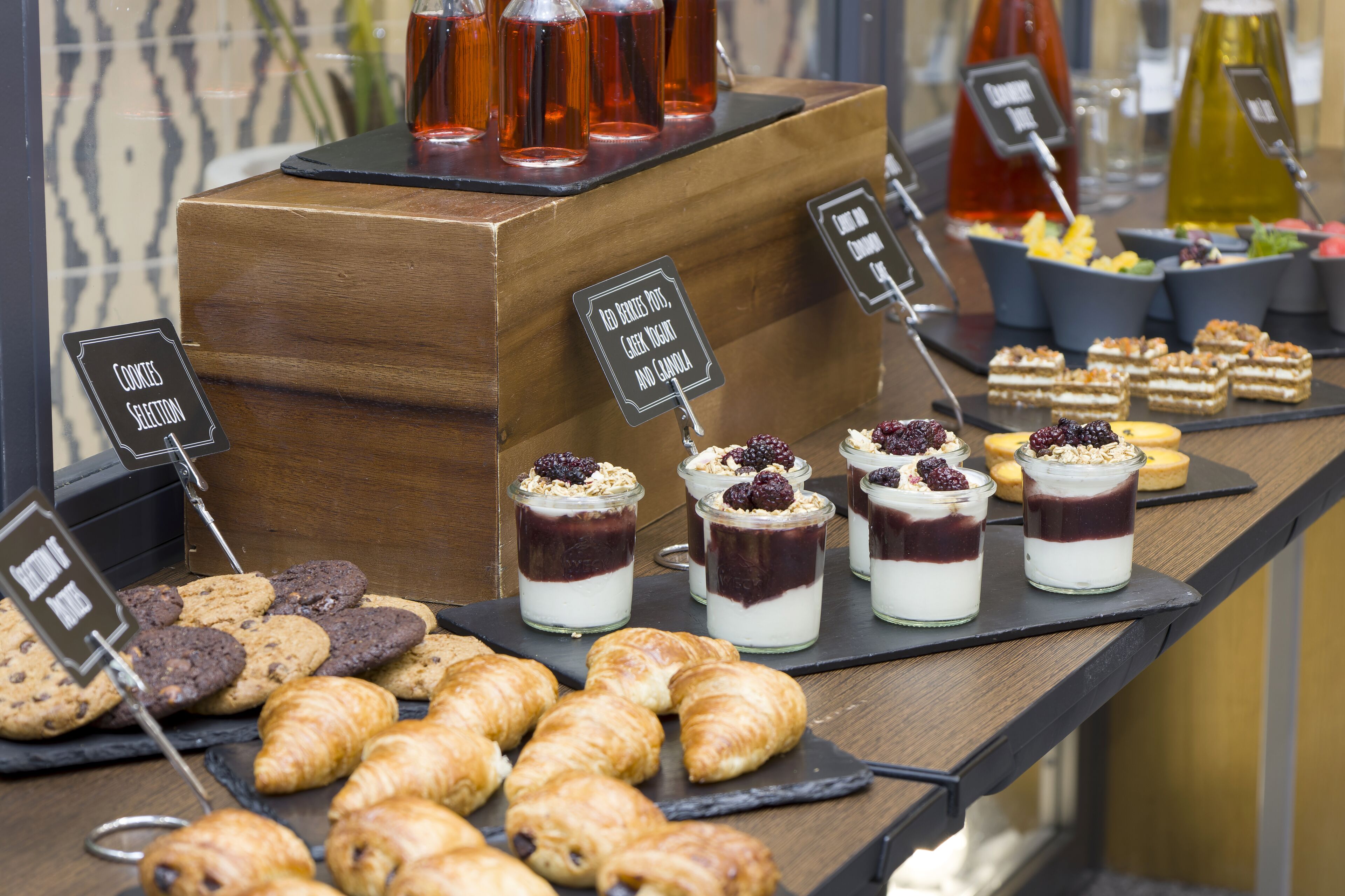 A breakfast buffet with various pastries, cookies, and desserts.