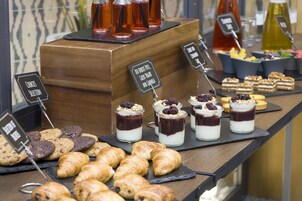 Ein Frühstücksbuffet mit verschiedenen Backwaren, Keksen und Desserts.